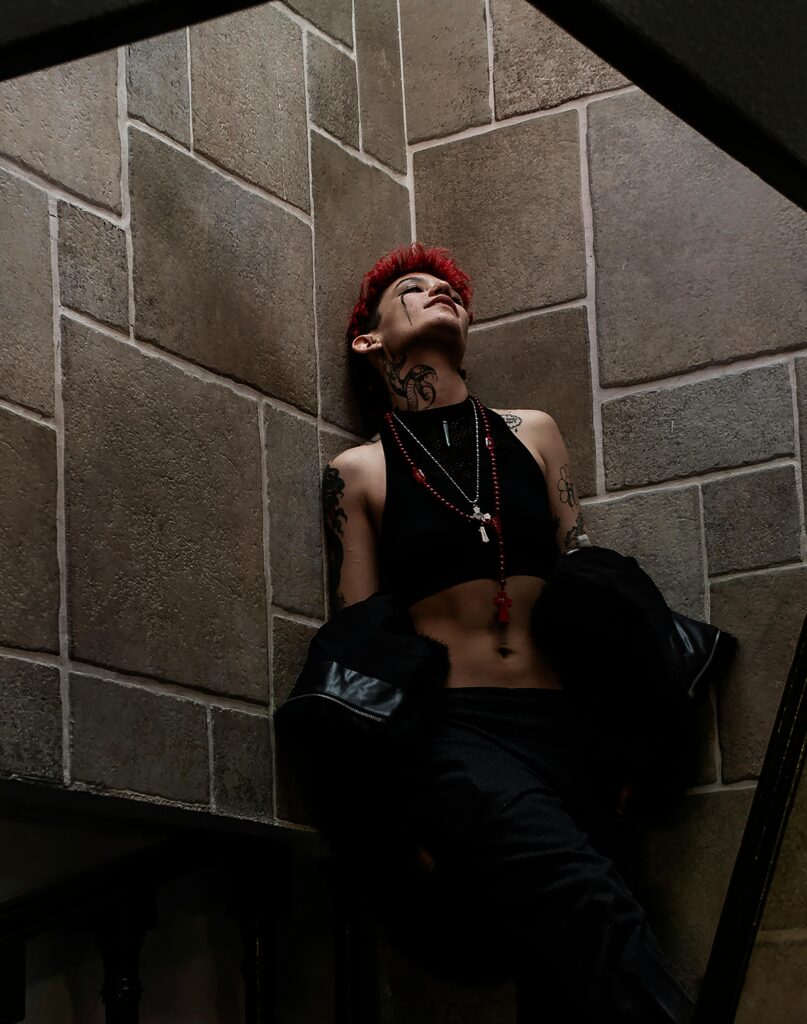 Stylish woman with tattoos and red hair posing in cool urban setting, Mexico City.